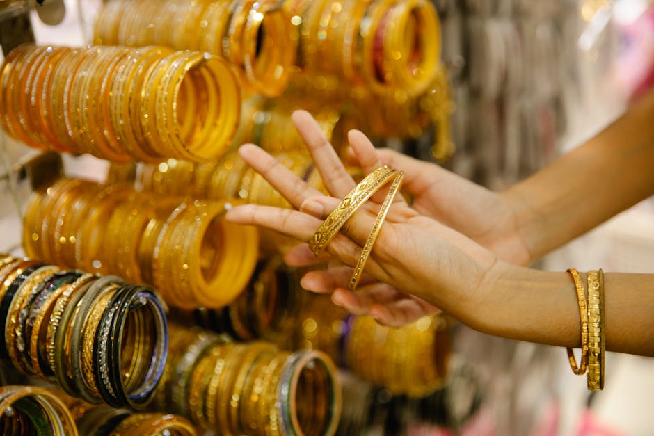 Woman inspects gold coin amidst jewelry display on Akshaya Tritiya